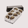 Saratoga Chocolate Co. Pistachio Truffle Collection featuring eight truffles nestled in white paper cups within a clear box. Each truffle showcases a dark chocolate shell topped with finely ground salted pistachios.