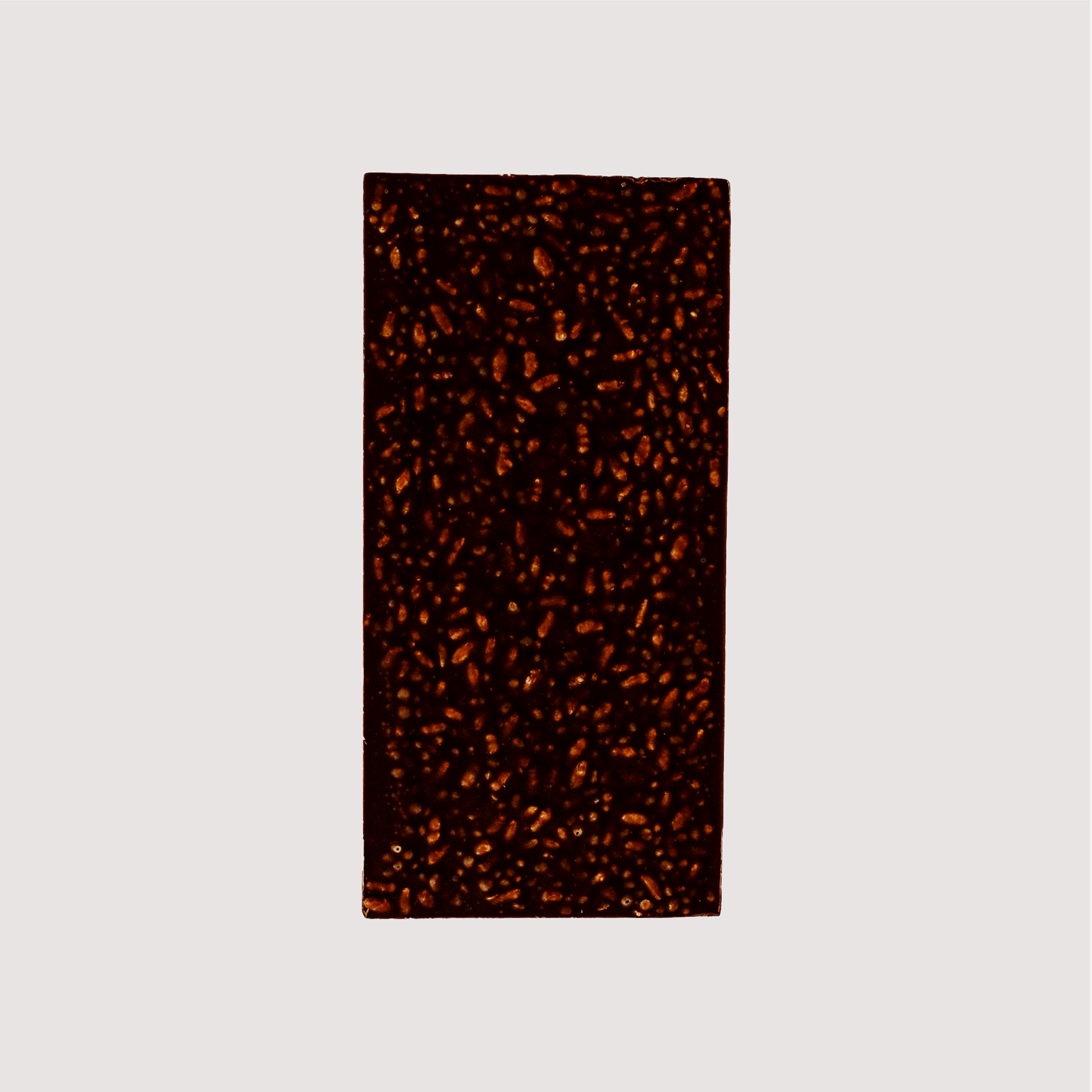 Unwrapped Saratoga Chocolate Co. Dark Crunch Bar, back side showing textured surface with visible organic puffed brown rice and quinoa embedded in the dark chocolate. This bar is gluten and dairy free.