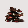 Stack of Saratoga Chocolate Co. Strawberry Hazelnut Dark Chocolate Bark pieces, featuring rich dark chocolate topped with freeze-dried strawberry slices and roasted hazelnuts. This bark is gluten free.