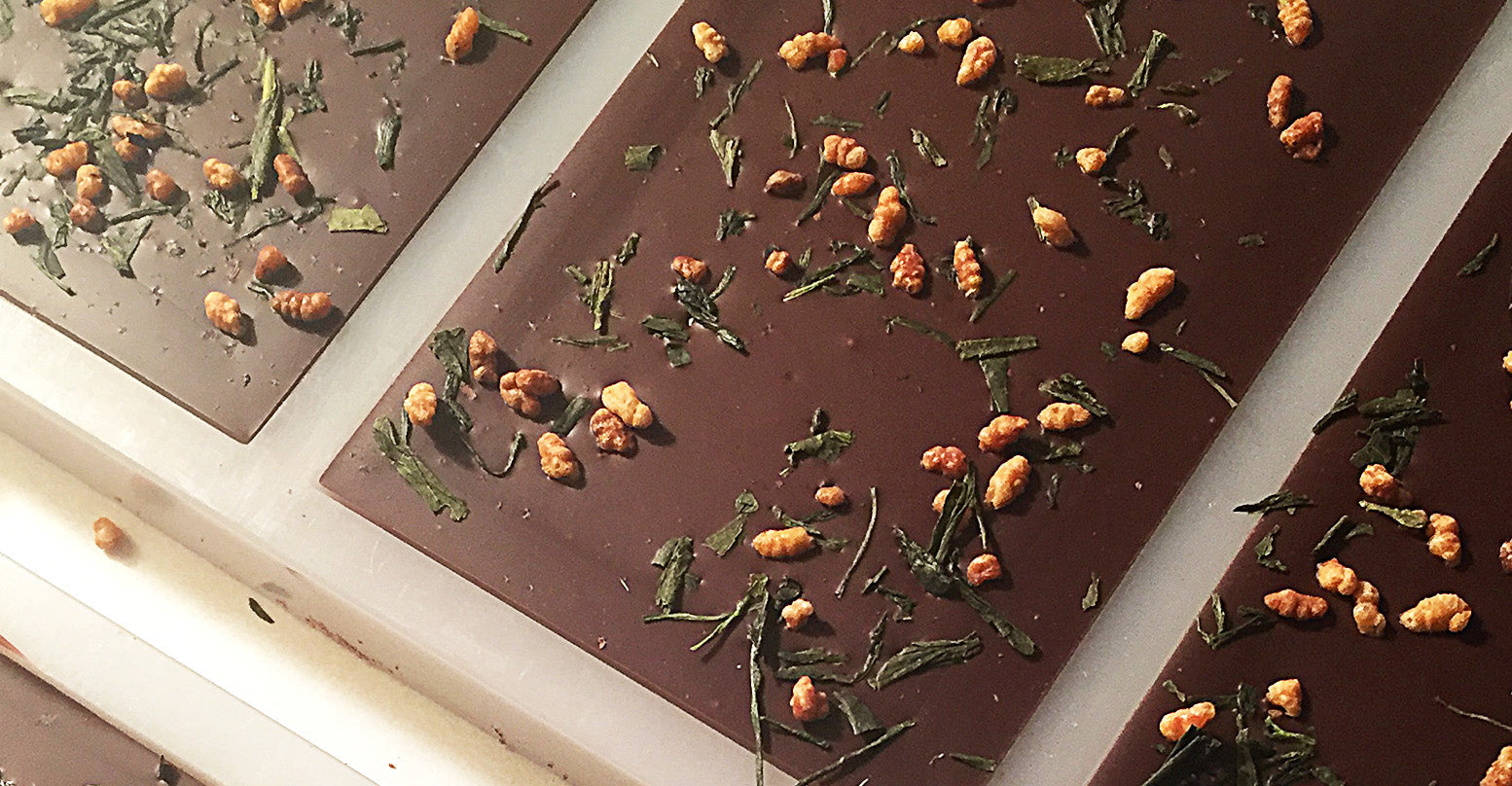 A back side of a dark chocolate bar by Saratoga Chocolate Co with green tea and brown rice on it 
