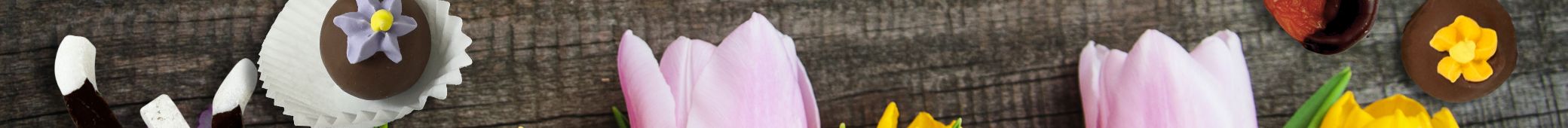 Elements of flowers and chocolate truffles on a dark wooden surface