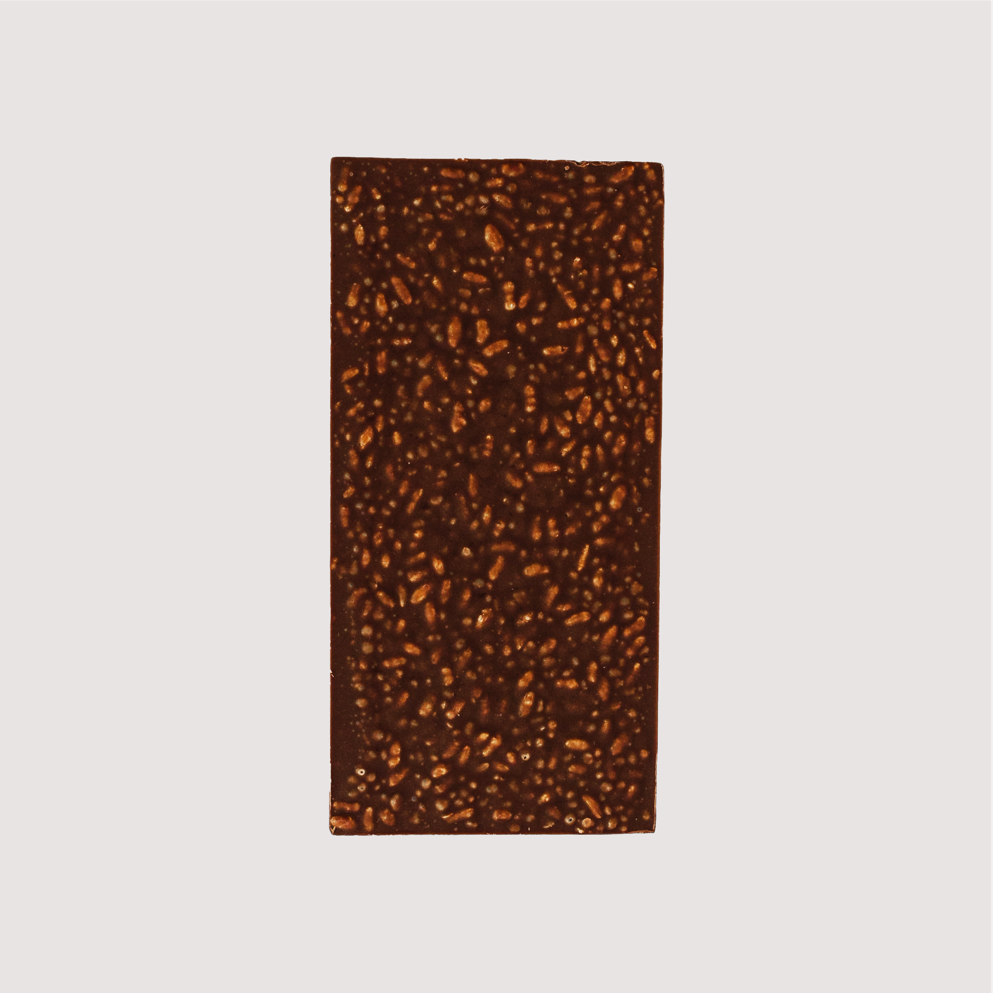 Unwrapped Saratoga Chocolate Co. Bodhi Bar, back side showing textured surface with visible organic puffed brown rice and quinoa embedded in the milk chocolate. This bar is gluten free.