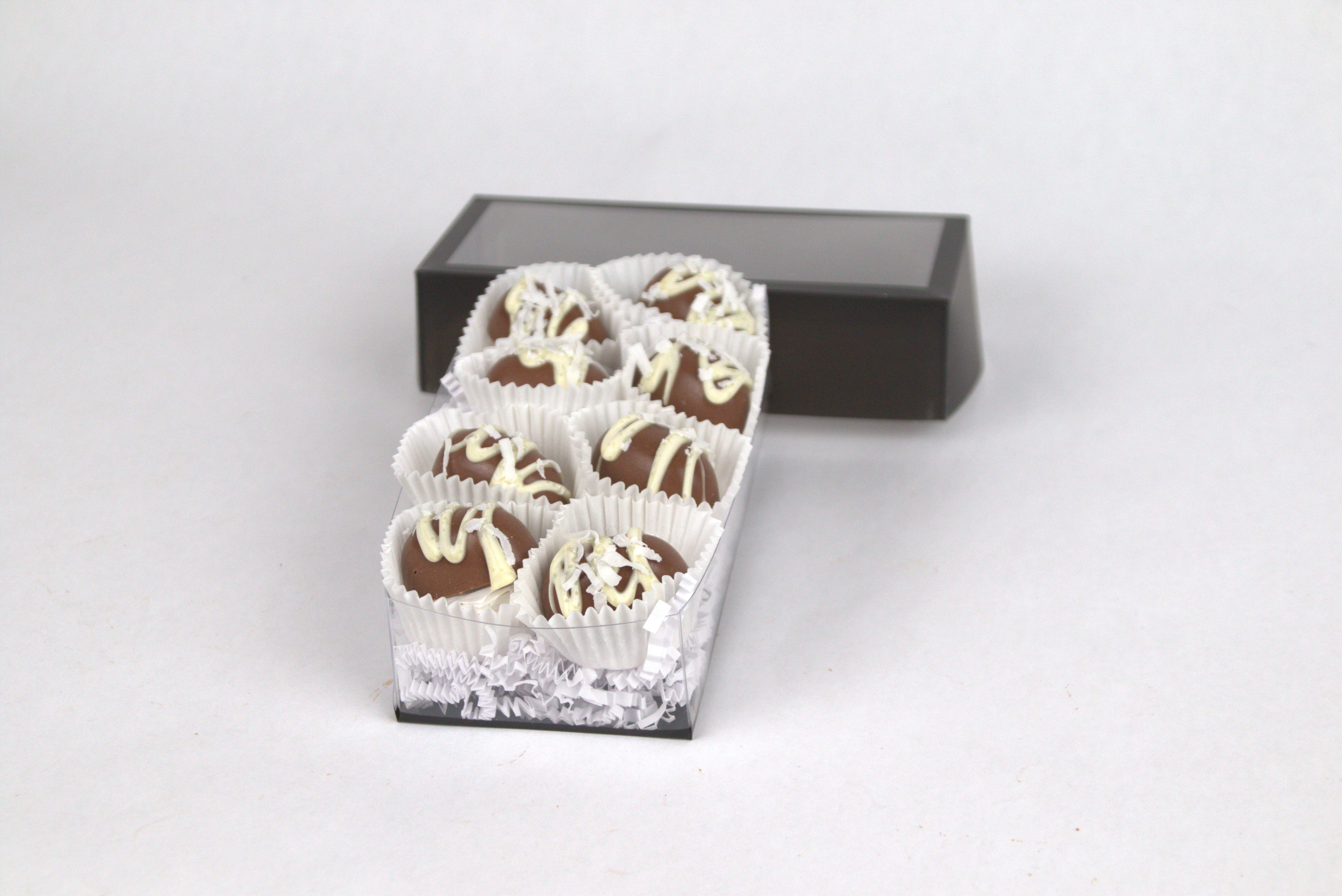 Box of eight Coconut Milk Chocolate Truffles, featuring silky coconut ganache inside creamy milk chocolate shells, finished with white chocolate drizzle and shredded coconut flakes — a tropical gourmet treat from Saratoga Chocolate Co.