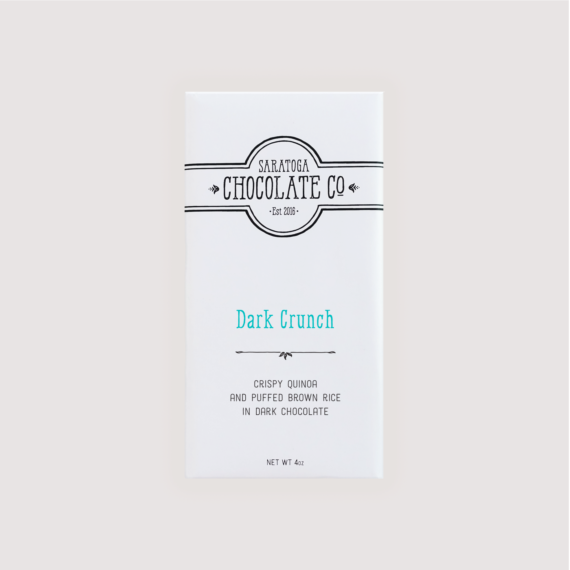 Front of Saratoga Chocolate Co. Dark Crunch Bar wrapped in a white paper package with a teal-colored flavor label. Label features the Saratoga Chocolate Co. logo and describes the bar as dark chocolate with crispy organic puffed brown rice and crunchy organic puffed quinoa. This bar is gluten and dairy free. 
