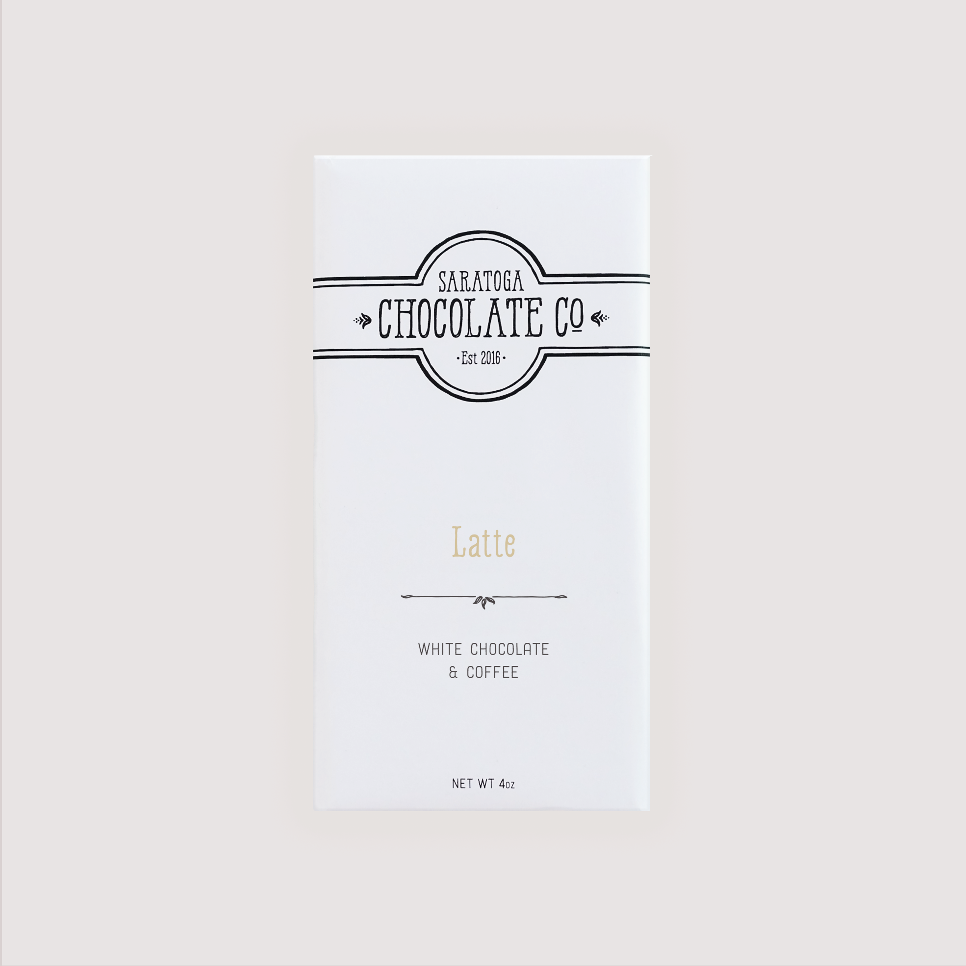 Front of Saratoga Chocolate Co. Latte Bar wrapped in a white paper package with a soft tan flavor label. Label features the Saratoga Chocolate Co. logo and describes the bar as white chocolate and coffee. This bar is gluten free.