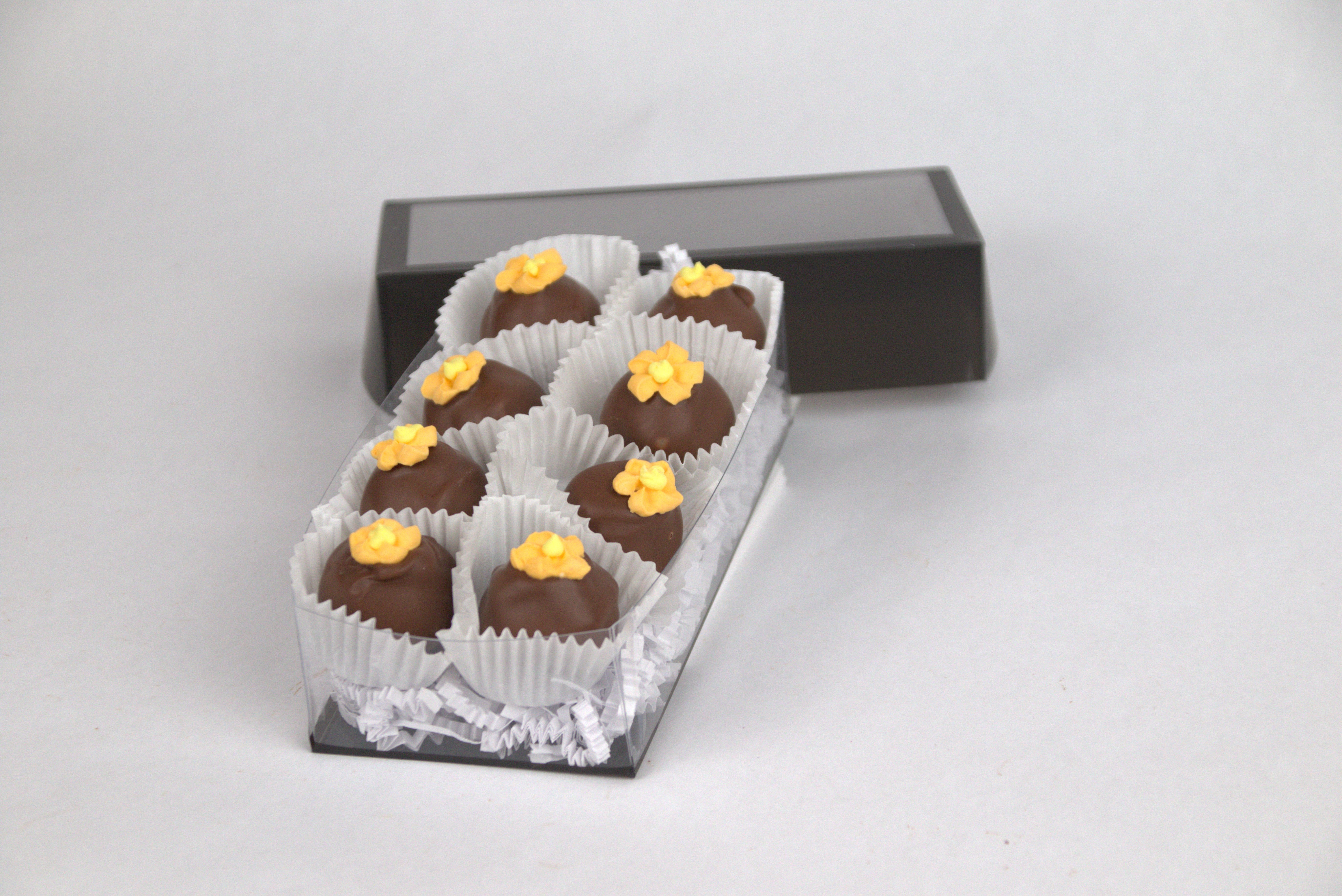 Box of eight Orange Blossom Truffles, handcrafted with smooth milk chocolate ganache and topped with delicate orange sugar flowers — a sweet and floral gourmet treat from Saratoga Chocolate Co.