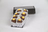 Box of eight Orange Blossom Truffles, handcrafted with smooth milk chocolate ganache and topped with delicate orange sugar flowers — a sweet and floral gourmet treat from Saratoga Chocolate Co.