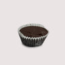 One Milk Chocolate Peanut Butter Cup placed in a white paper cup, sitting on a light, neutral background. The chocolate has a smooth, glossy top and is presented simply to highlight its rich texture.