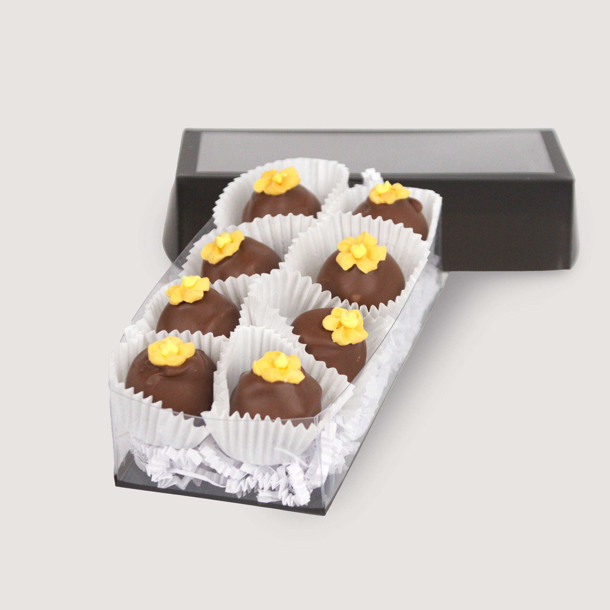 Box of eight Orange Blossom Truffles, handcrafted with smooth milk chocolate ganache and topped with delicate orange sugar flowers — a sweet and floral gourmet treat from Saratoga Chocolate Co.