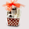 A gift basket with Nibbles, two vanilla marshmallows, Mexican  spiced almonds, Mayan spice hot chocolate jar, in a clear bag and red ribbon on top