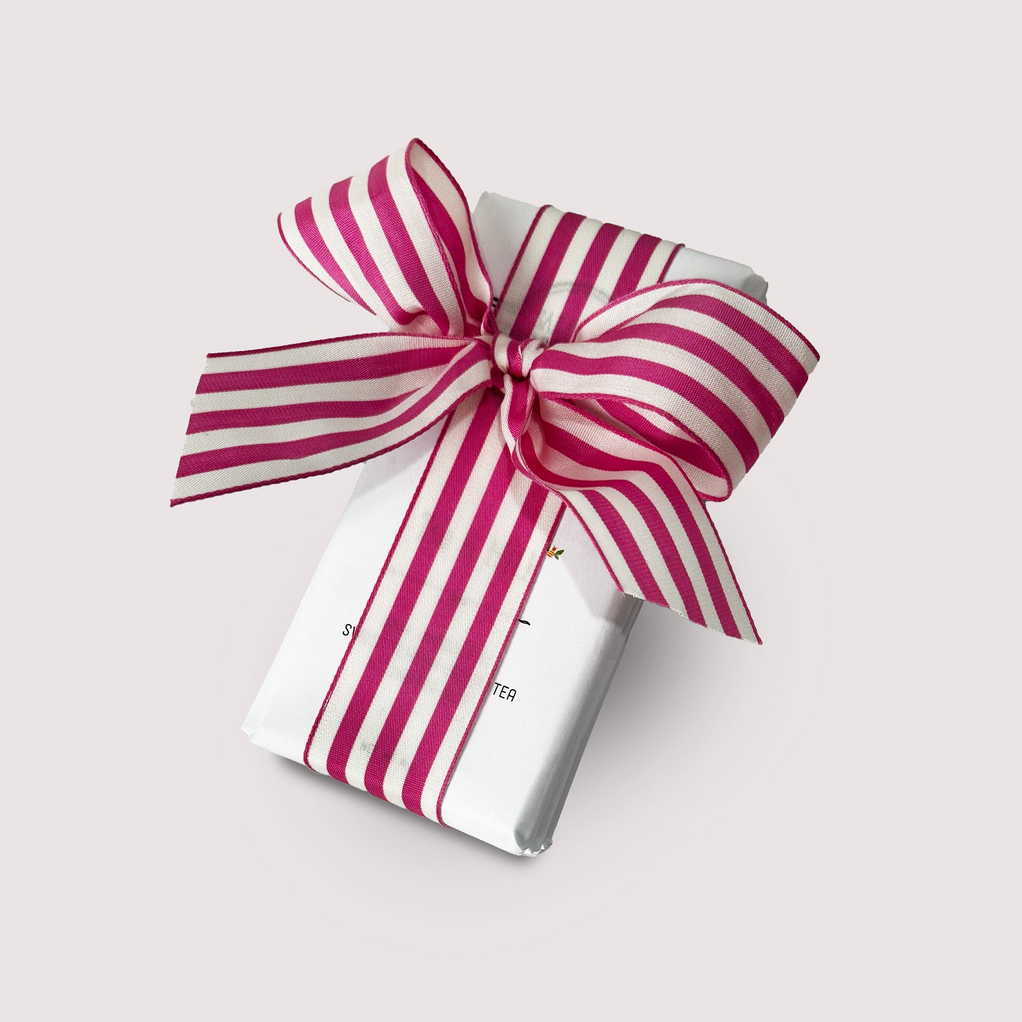 White stack of chocolate bars by Saratoga Chocolate Co with a pink and white striped bow on a light gray background