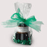 A small Saratoga Chocolate Co. St. Patrick’s Day chocolate bundle includes two handmade Irish Cream and two Irish Coffee truffles paired with a small jar of milk chocolate hot chocolate mix  In a clear bag with green ribbon on top.