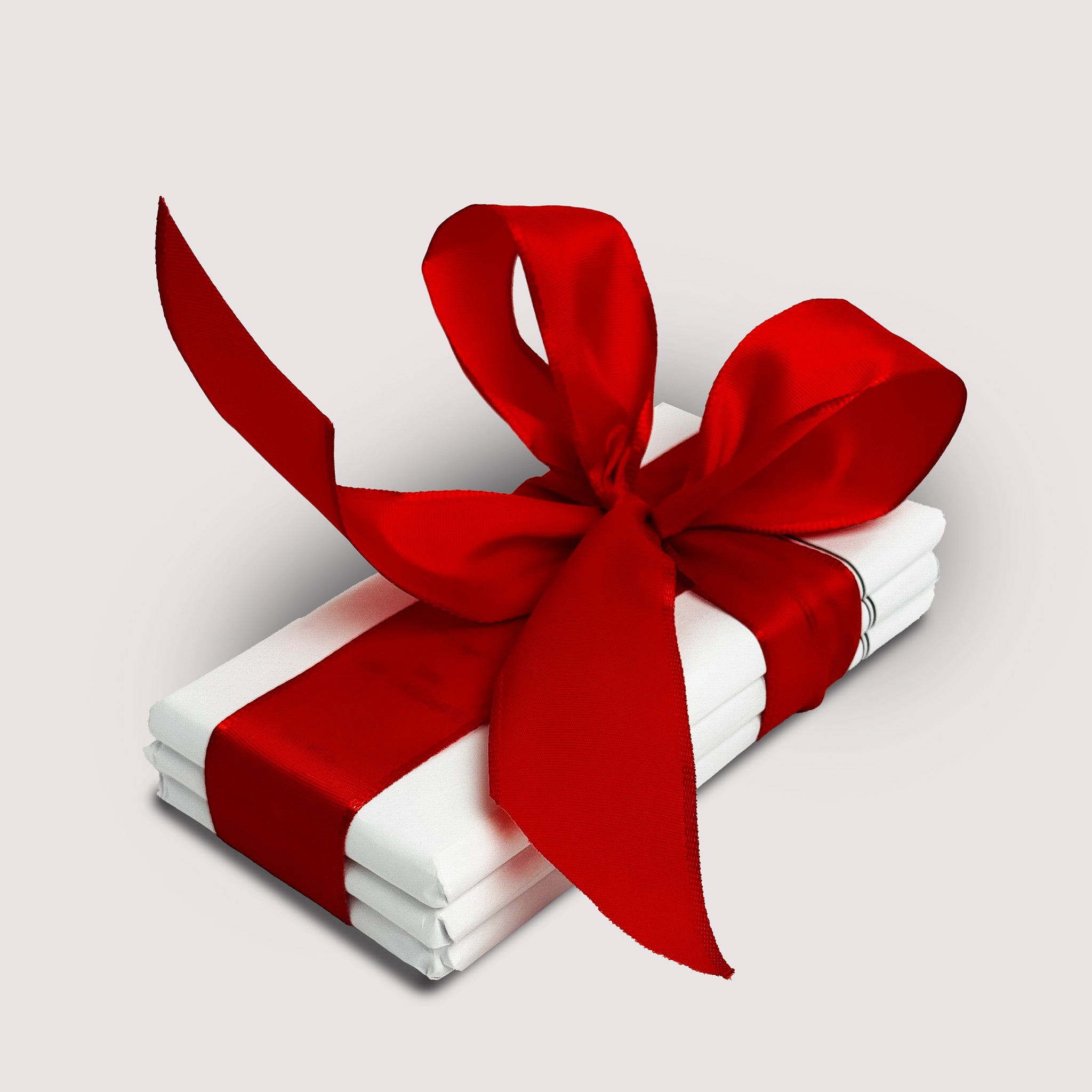 Stack of chocolate bars by Saratoga Chocolate Co with a red bow on a light gray backgrounds 