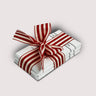 Stack of chocolate bars by Saratoga Chocolate Co with a red and white striped bow on a light gray backgrounds 