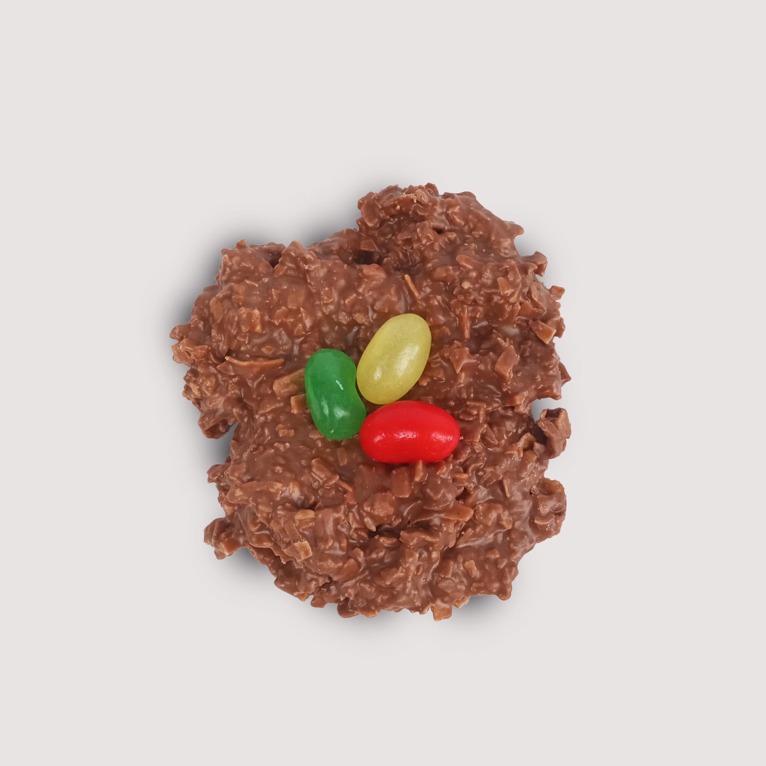 Milk chocolate blended with toasted coconut flakes, shaped into a small nest with three brightly colored jellybeans in the center. These delightful treats look like jellybean "eggs" nestled in a milk chocolate coconut "nest".