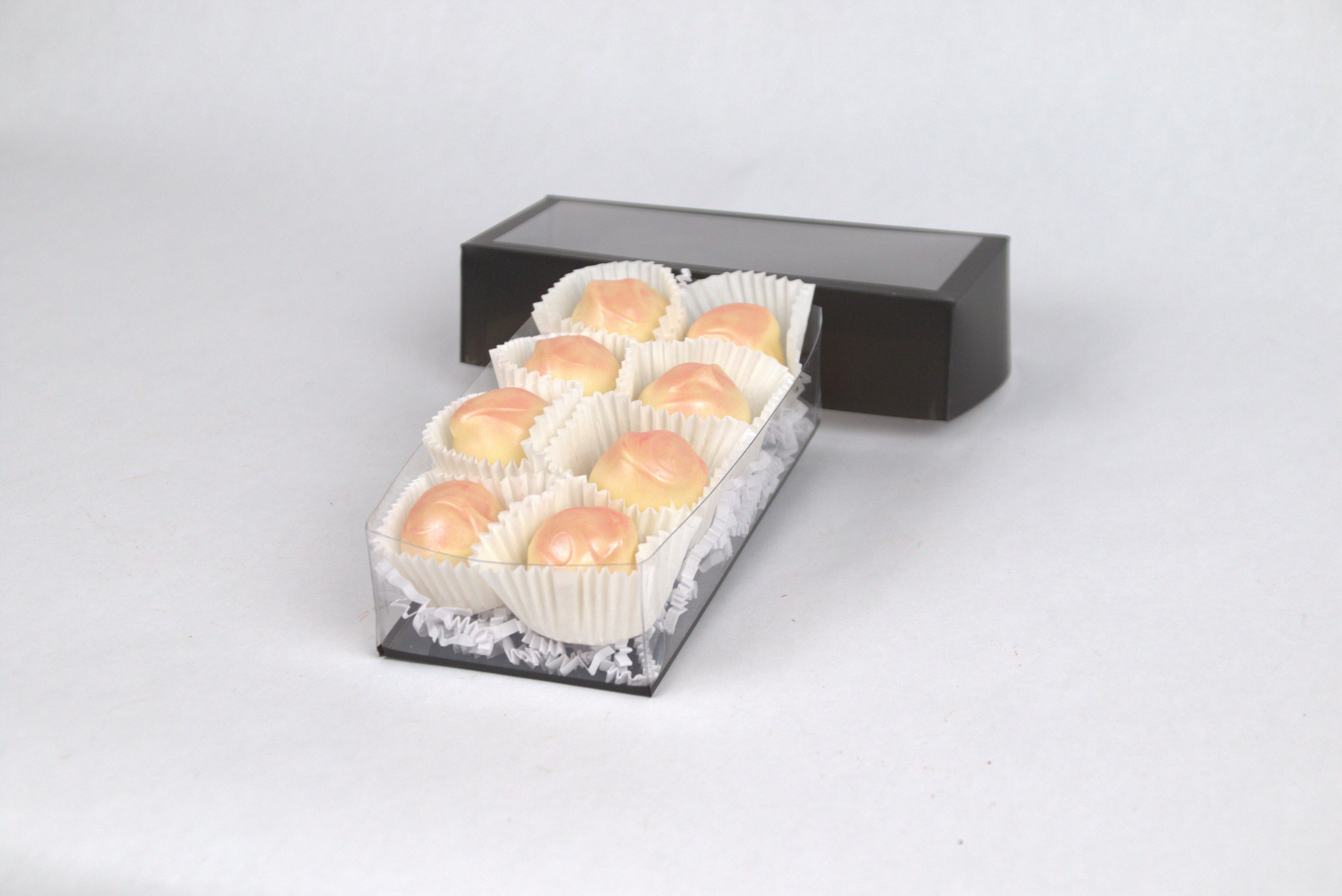 Box of eight Passion Fruit Truffles, each with tart tropical passion fruit ganache inside a creamy white chocolate shell, dusted with delicate pink pearl accents — a gourmet chocolate treat from Saratoga Chocolate Co.