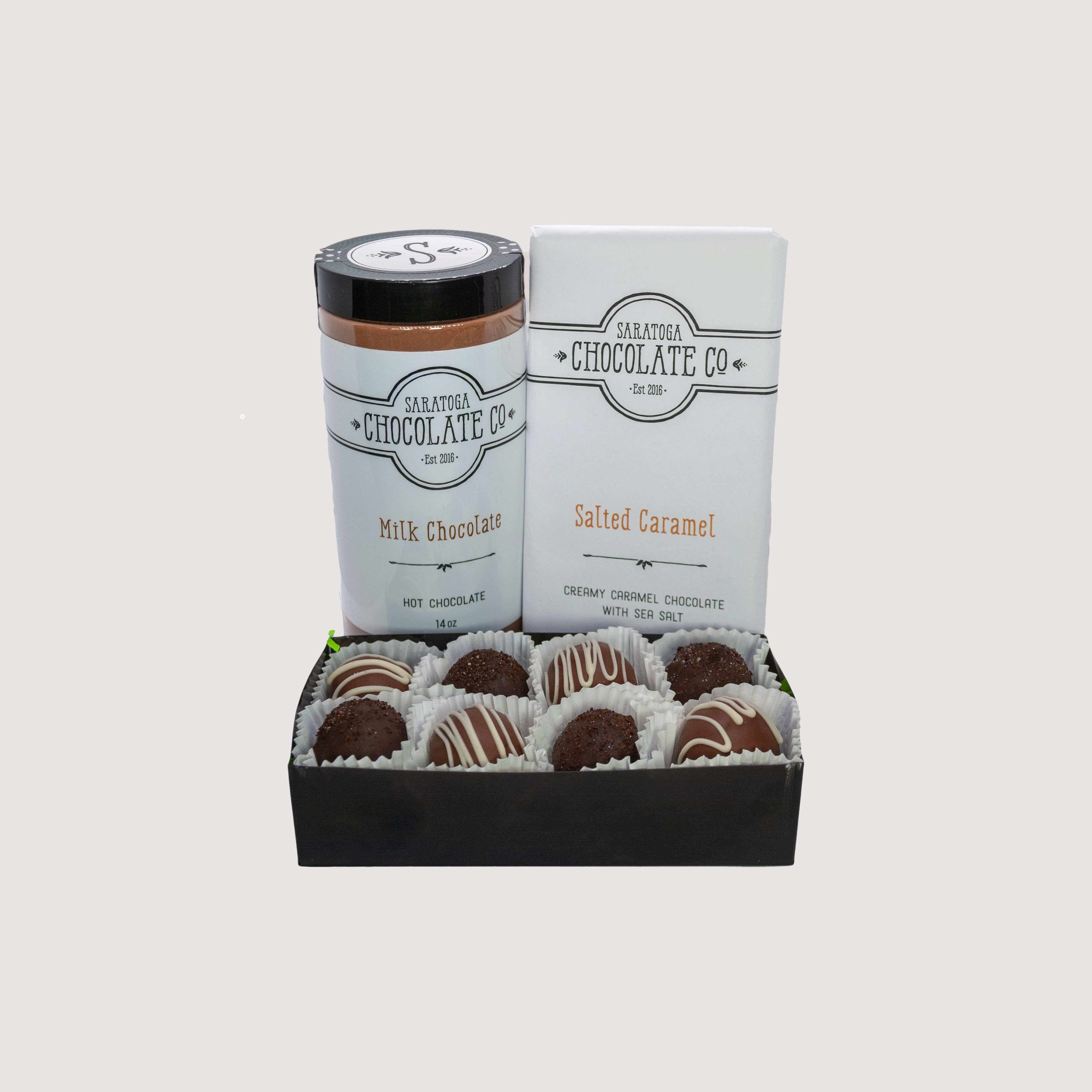 Saratoga Chocolate Co. St. Patrick’s Day gift set featuring Irish Cream and Irish Coffee truffles, a golden-wrapped Salted Caramel chocolate bar, and a tin of milk chocolate hot chocolate mix. A festive chocolate assortment perfect for celebrating St. Patrick’s Day.
