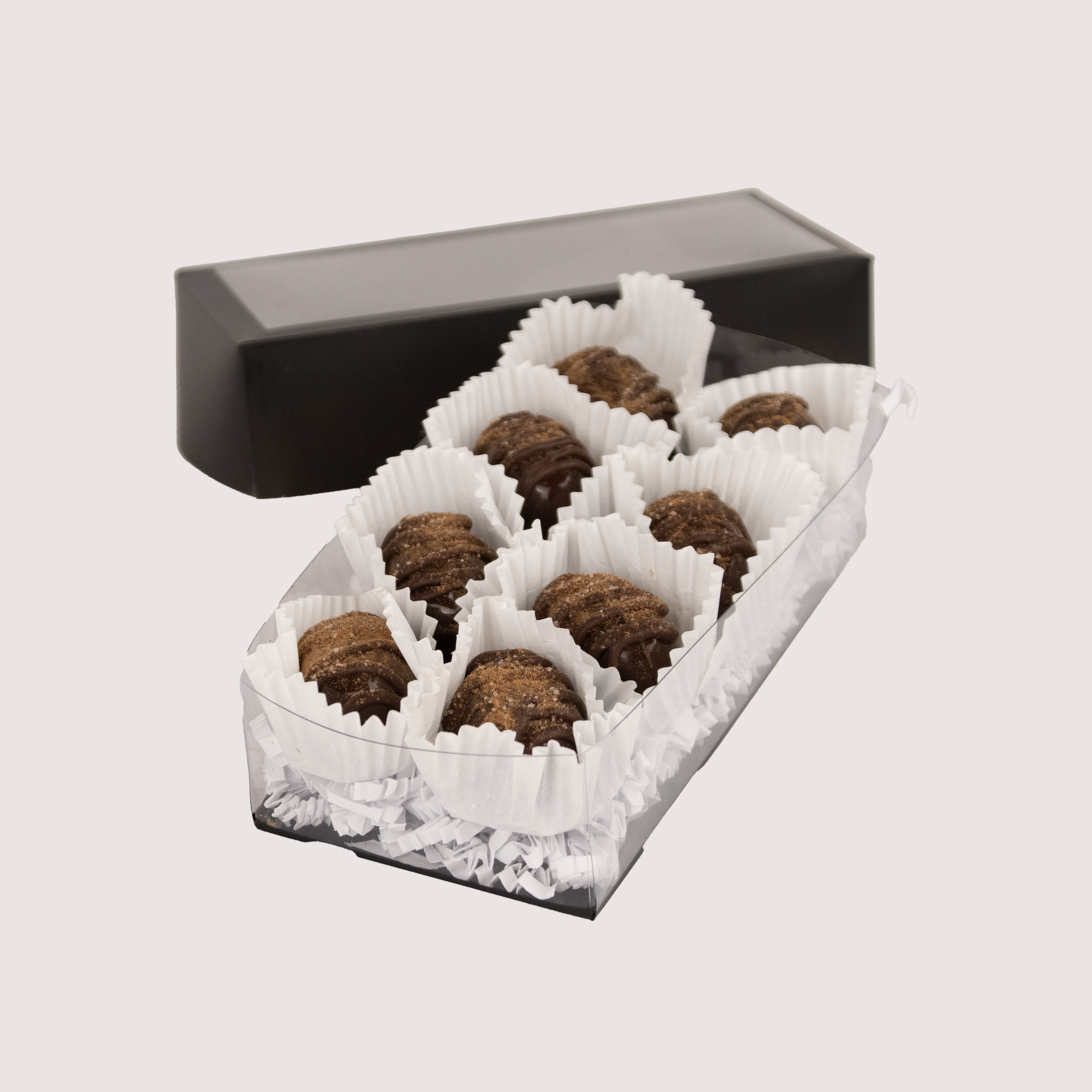 Box of 8 chocolate truffles by Saratoga Chocolate Co, arranged in a sleek black box with each truffle nestled in a paper cup.