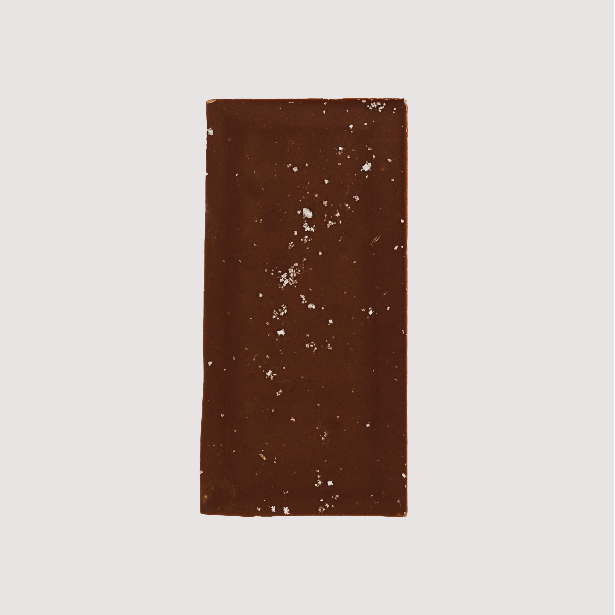 Unwrapped Saratoga Chocolate Co. Fleur de Lait Bar, back side revealing a textured surface with visible flakes of French sea salt sprinkled across the milk chocolate. This bar is gluten free.
