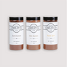From left to right: Saratoga Chocolate Co. 14-ounce jars of Dark Hot Chocolate Mix, Milk Hot Chocolate Mix, and Mayan Spice Hot Chocolate Mix. Each jar is labeled and sealed, showcasing the variety of gourmet drinking chocolate flavors. Hot Chocolate Mix, and Mayan Spice Hot Chocolate Mix are gluten and dairy free. Milk Hot Chocolate Mix is gluten free.