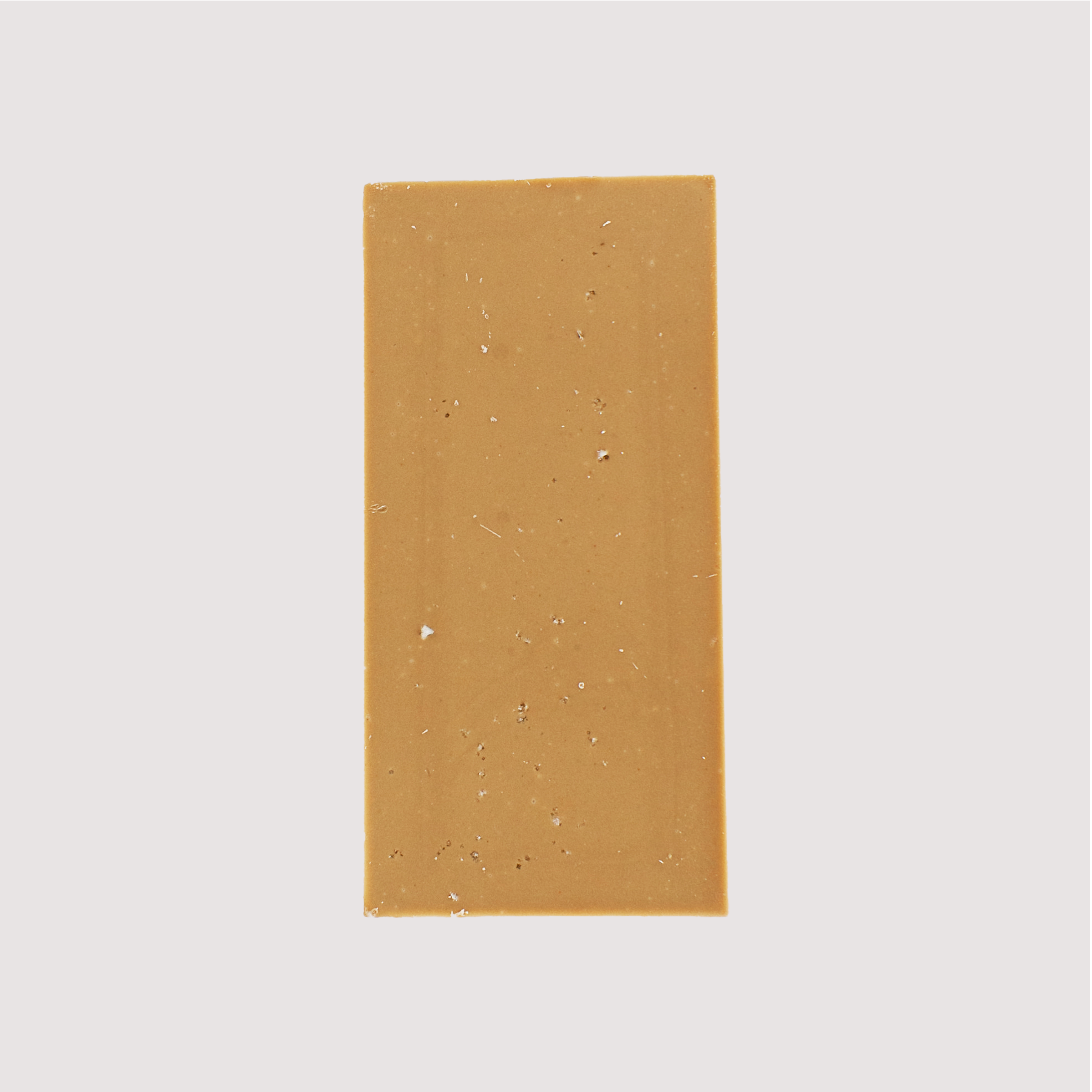 Back of an unwrapped Saratoga Chocolate Co. Salted Caramel chocolate bar with a deep golden hue and speckled with fleur de sel sea salt. The bar is made with caramelized sugar, giving it a rich color and creamy caramel flavor. This bar is gluten free.